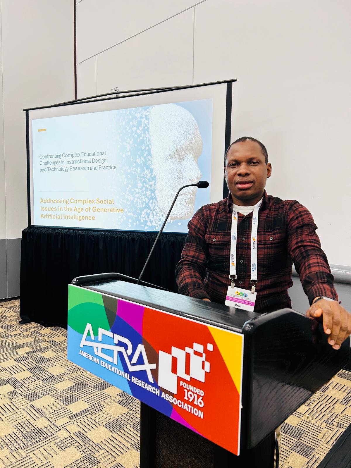 David Awoyemi presenting at a conference podium